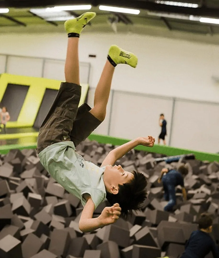 Jeune sauteur en pleine rotation au-dessus de la fosse à mousse
