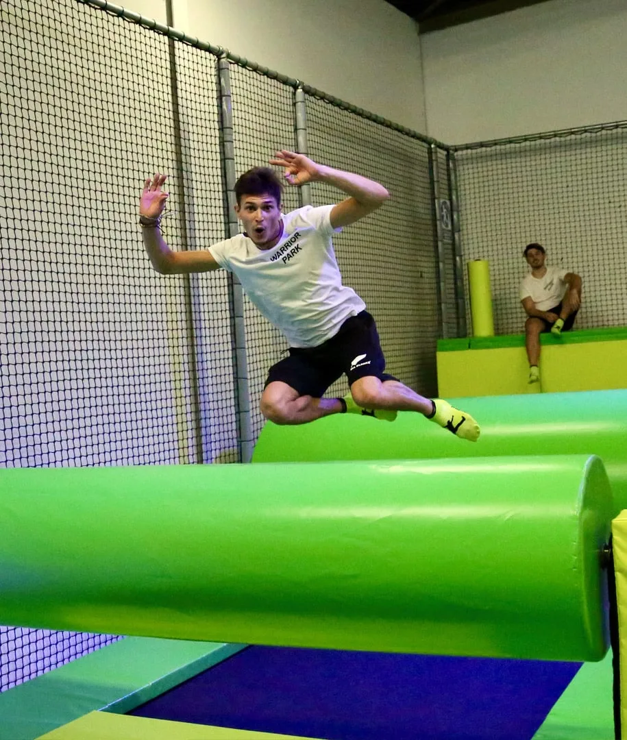 Sauteur franchissant un rouleau vert du parcours Big Bounce