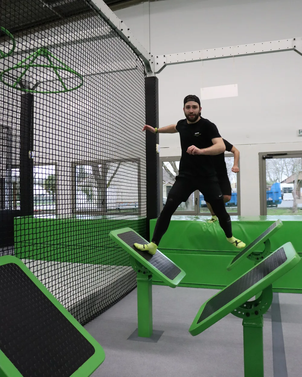 Participant franchissant les plateformes inclinées du parcours Ninja Warrior