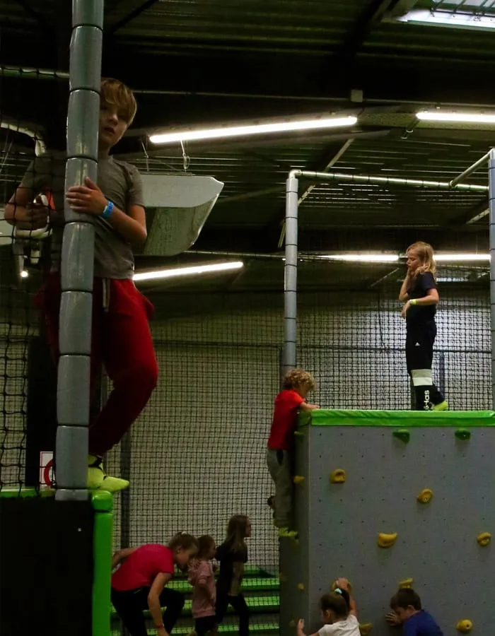 Enfants répartis sur les plateformes et le mur d’escalade