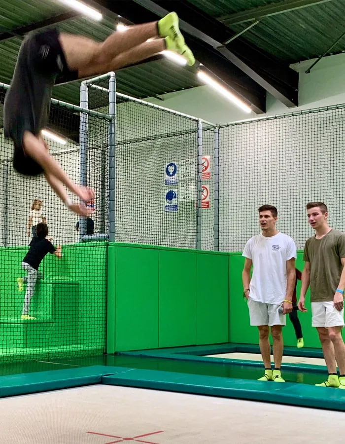 Salto au-dessus des trampolines, sous le regard de deux amis