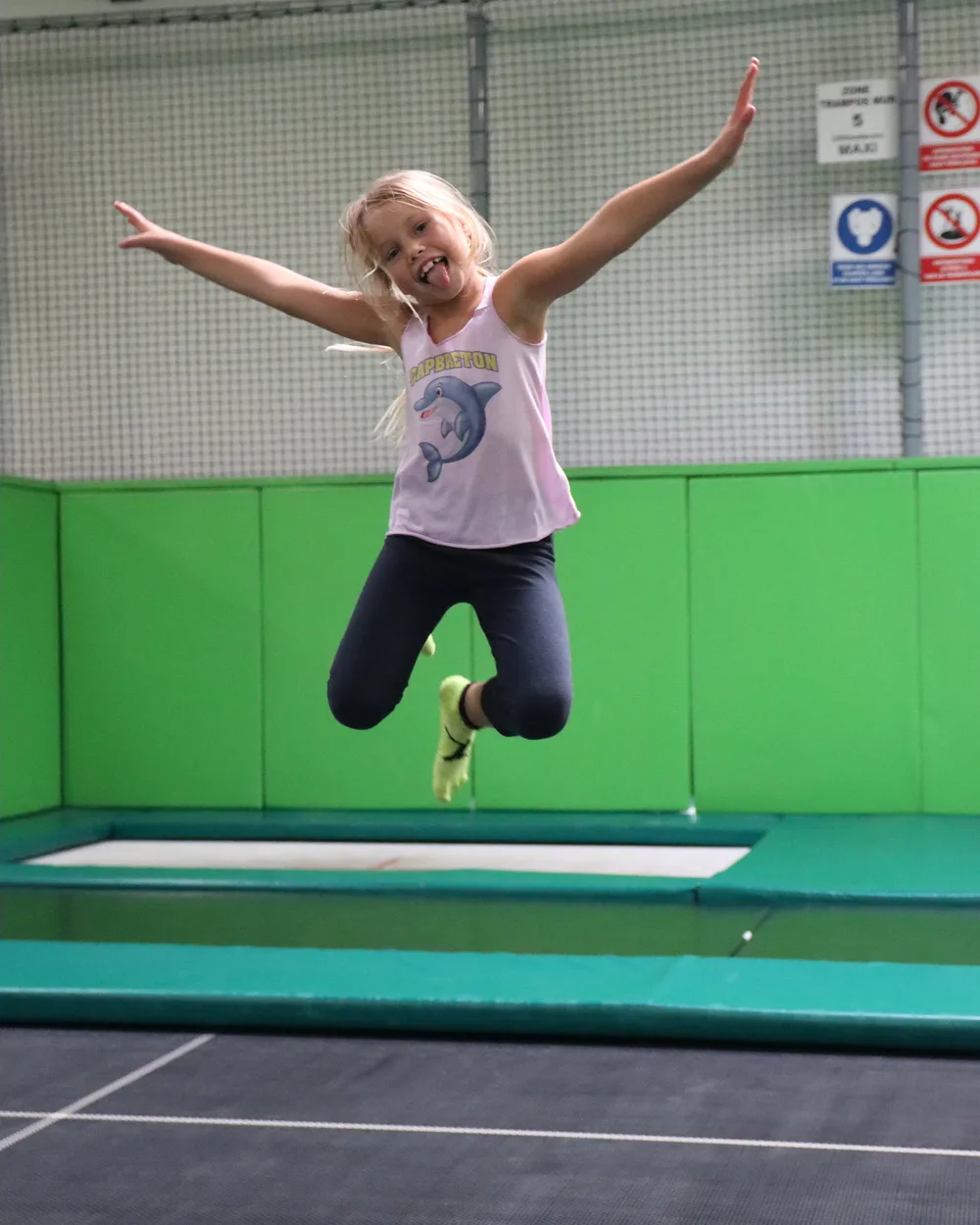 Fillette bras ouverts au-dessus d’un trampoline du Main Court
