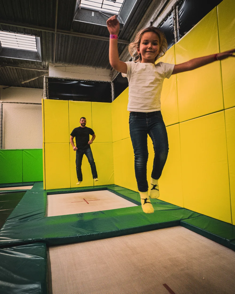 Fillette en plein saut devant les murs jaunes du Main Court
