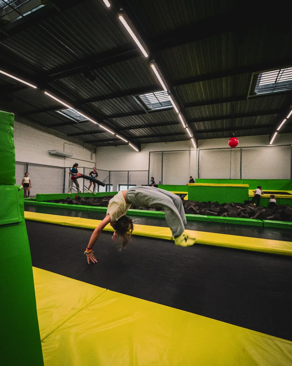 Salto arrière en contre-plongée au-dessus des trampolines jaunes