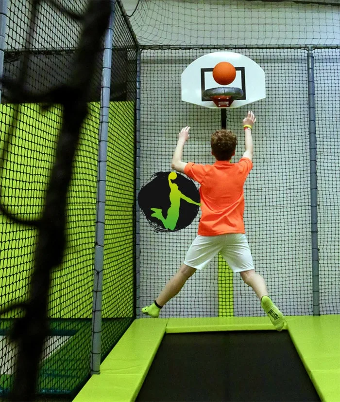 Sauteur s’élevant vers le panier de basket depuis le trampoline