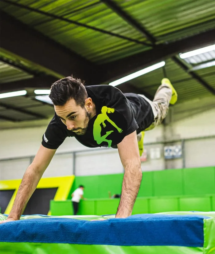 Sauteur à l’horizontale au-dessus d’un tapis, en appui sur les mains
