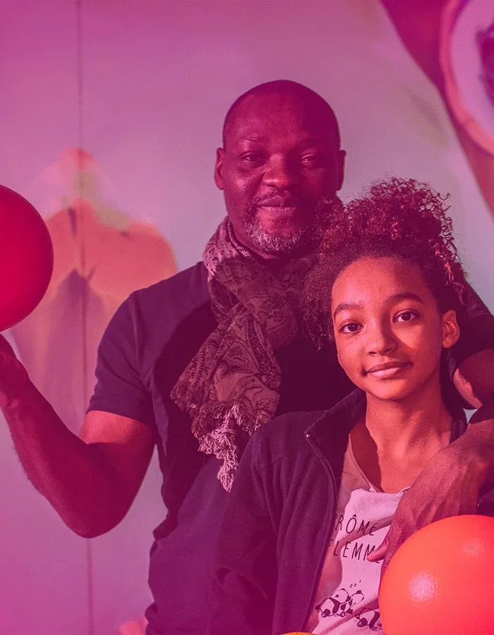 Un père et sa fille, balles en main, devant la projection de l’arène