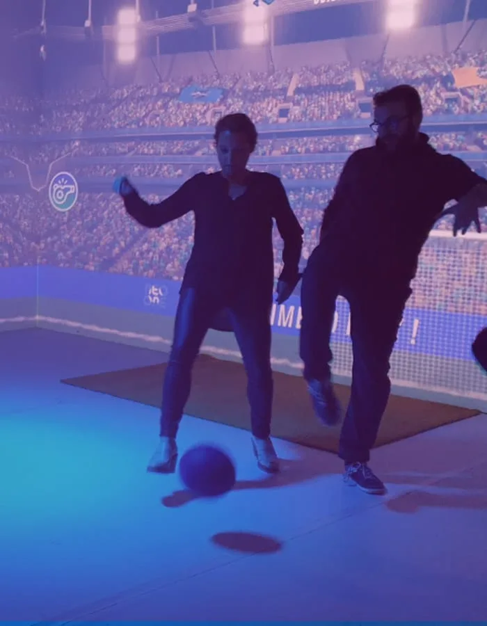Deux joueurs disputent un ballon devant un stade projeté