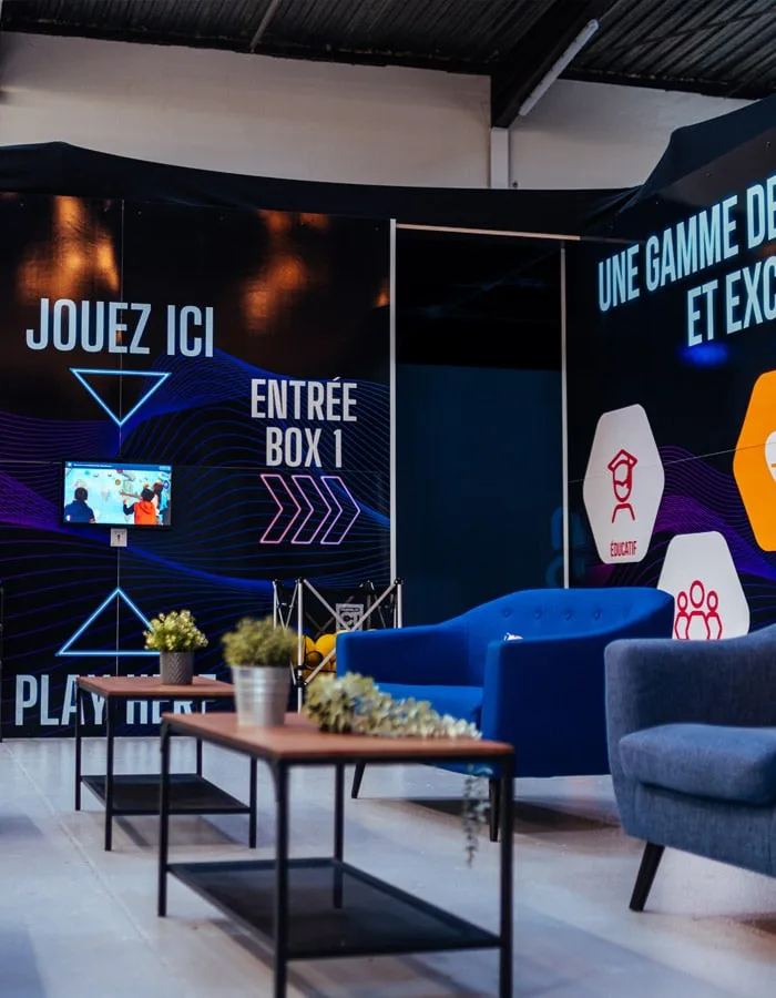 Salon de la No One Arena, fauteuils bleus devant les box de réalité augmentée